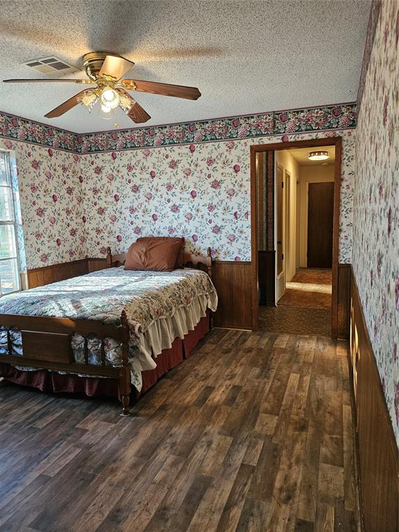 1447 Red Gate Road Mart, TX 76664 - Photo 8 of 19 a bedroom with a bed and a chandelier