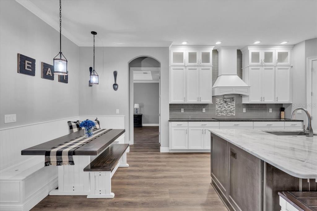 8011 Revels Road Riverview, FL 33569 - Photo 11 of 38 a kitchen with a sink stove and white cabinets with wooden floor