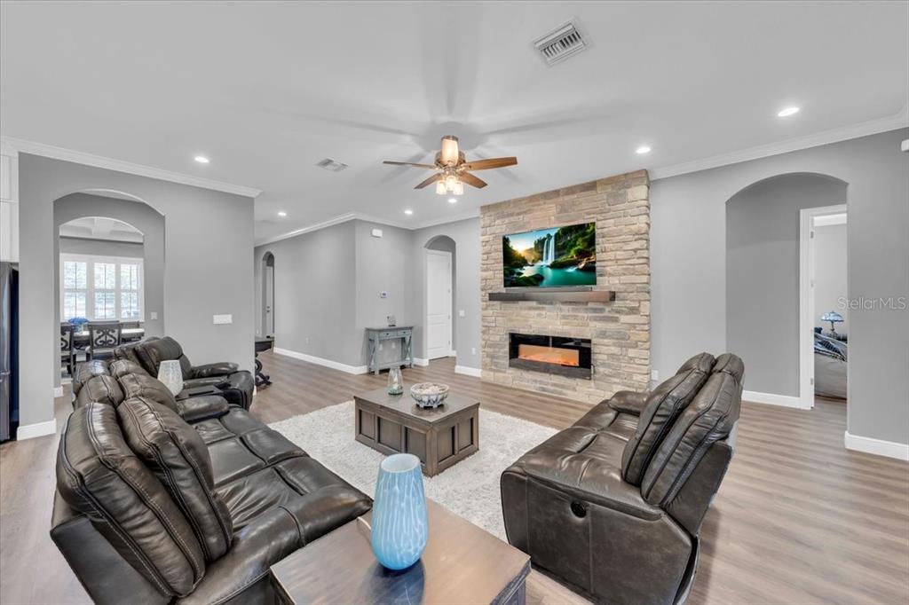 8011 Revels Road Riverview, FL 33569 - Photo 5 of 38 a living room with fireplace furniture and a wooden floor
