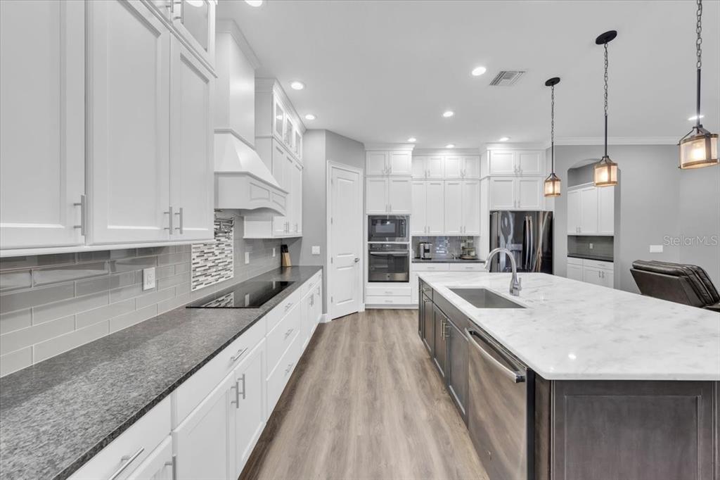 8011 Revels Road Riverview, FL 33569 - Photo 10 of 38 a large kitchen with kitchen island a large counter space a sink appliances and cabinets