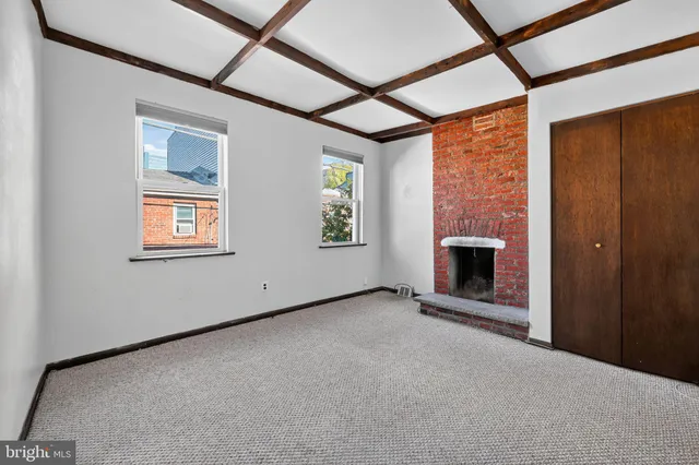 a view of an empty room with a fireplace and a window