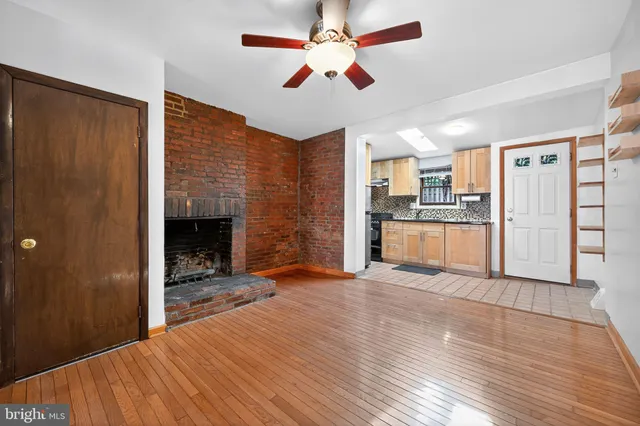 a view of a kitchen with wooden floor and a ceiling fan
