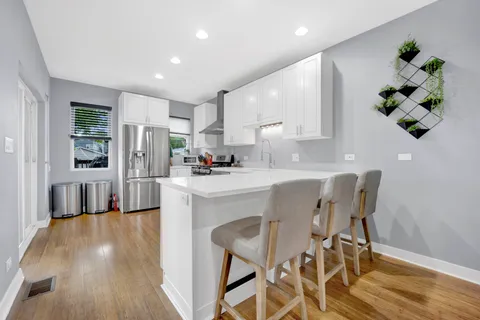 a kitchen with granite countertop white cabinets and stainless steel appliances