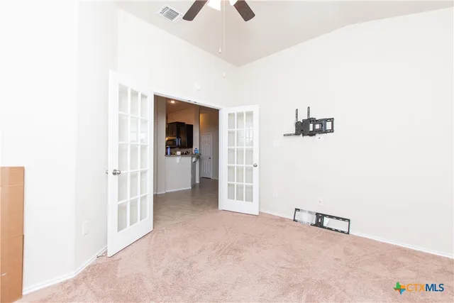 a view of a livingroom with wooden floor and a ceiling fan