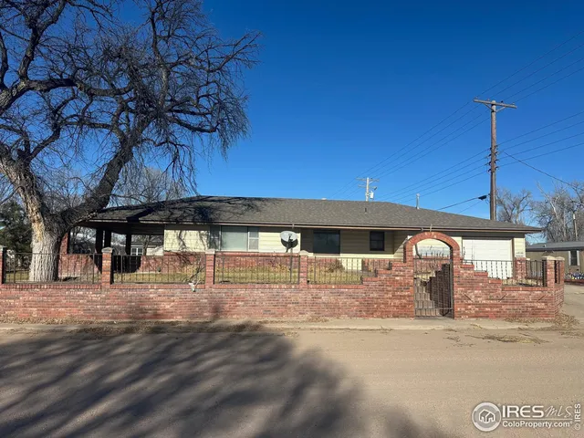 a backyard of a house with barbeque oven and outdoor seating