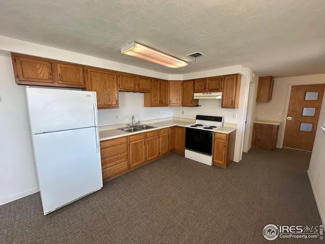 a kitchen with stainless steel appliances granite countertop a refrigerator a stove a sink a microwave and cabinets