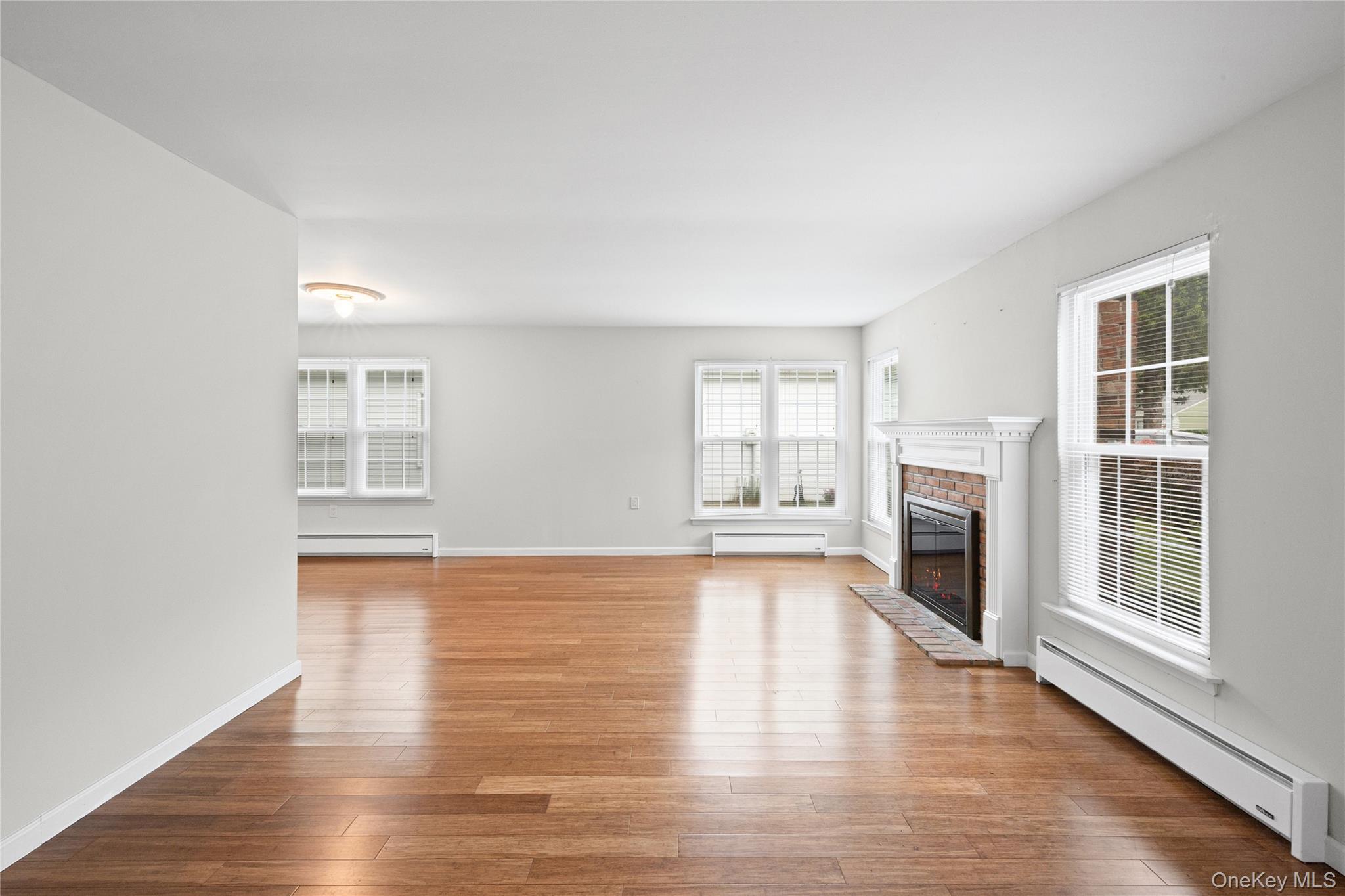 220 Belfast Lane Ridge, NY 11961 - Photo 9 of 44 a view of empty room with wooden floor and fireplace