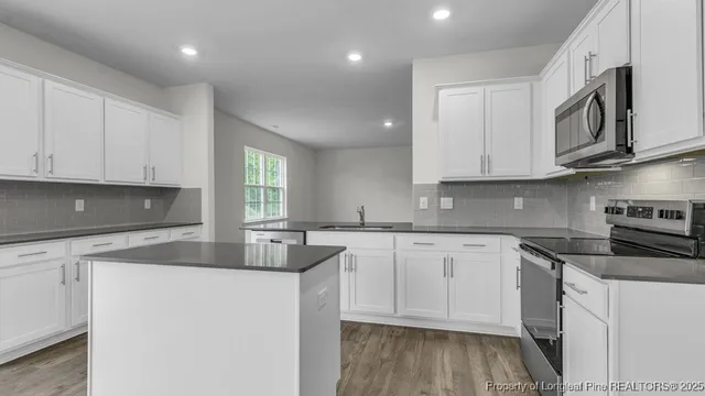a kitchen with granite countertop a sink stainless steel appliances and cabinets