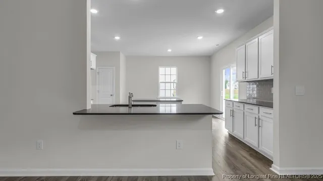 a view of a kitchen with a sink and dishwasher a refrigerator with wooden floor