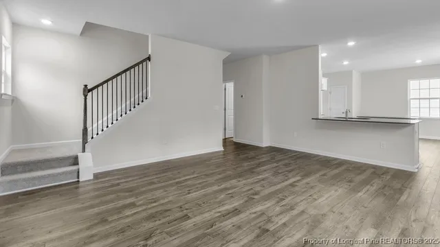 a view of a hallway with wooden floor and staircase