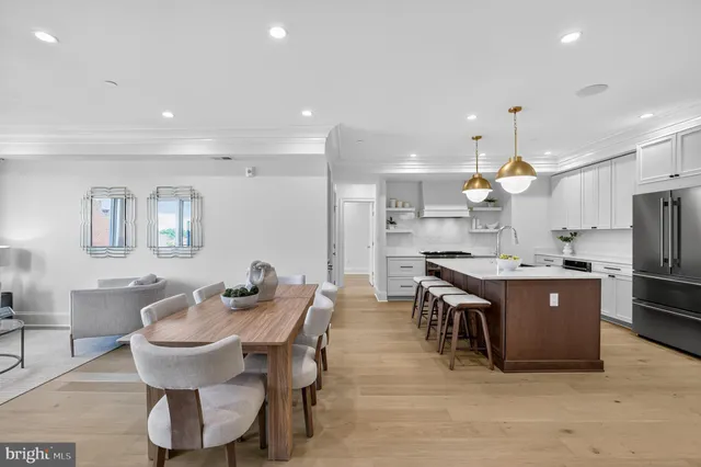 a kitchen with a dining table chairs stove a sink and a refrigerator