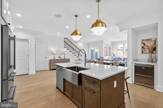 a kitchen with stainless steel appliances granite countertop a sink a stove and a wooden floors