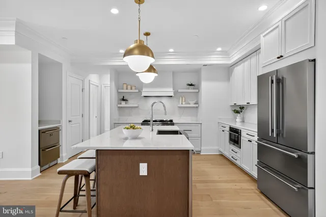 a kitchen with stainless steel appliances granite countertop a sink refrigerator and cabinets