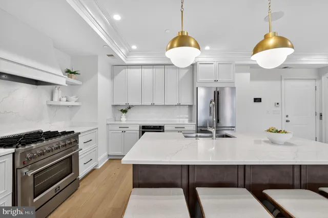 a kitchen with a sink a stove and chairs