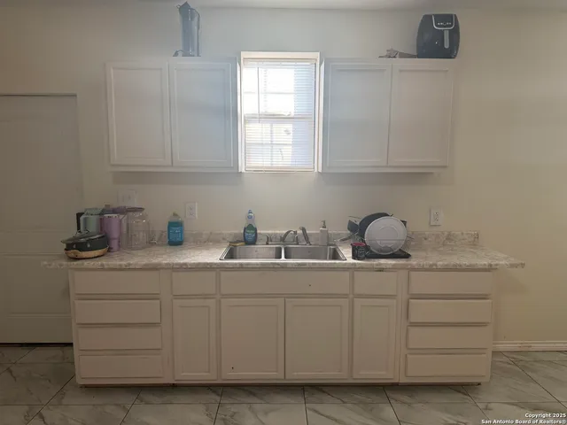 a kitchen with white cabinets and white appliances