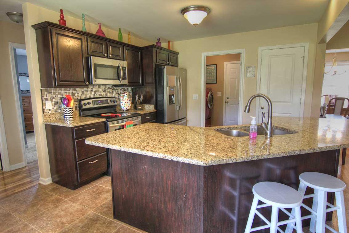 3928 Rowland Road Murfreesboro, TN 37128 - Photo 8 of 25 a kitchen with kitchen island granite countertop a stove top oven microwave and refrigerator
