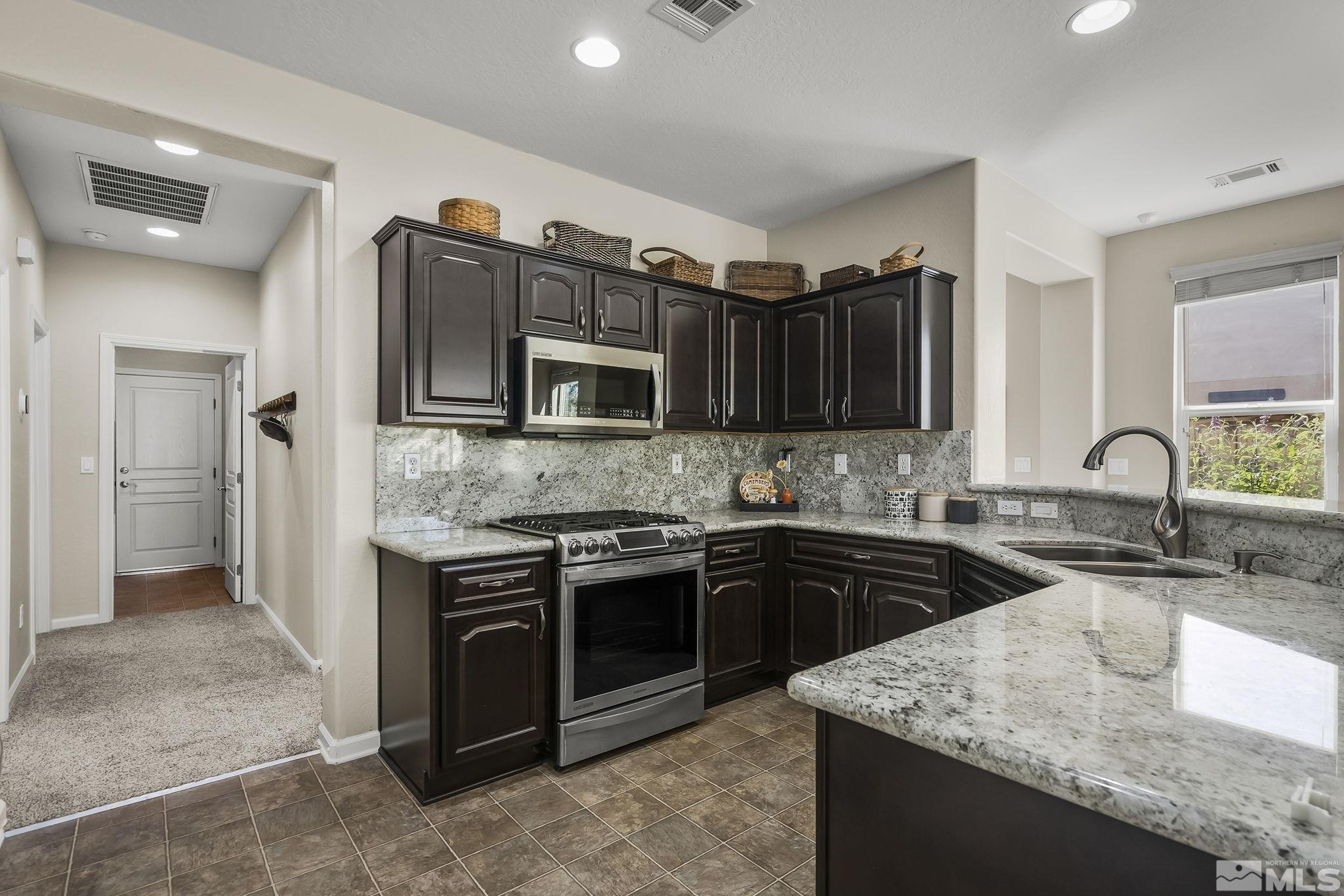 1375 Tarleton Way Reno, NV 89523 - Photo 4 of 22 a kitchen with stainless steel appliances granite countertop a sink stove and refrigerator