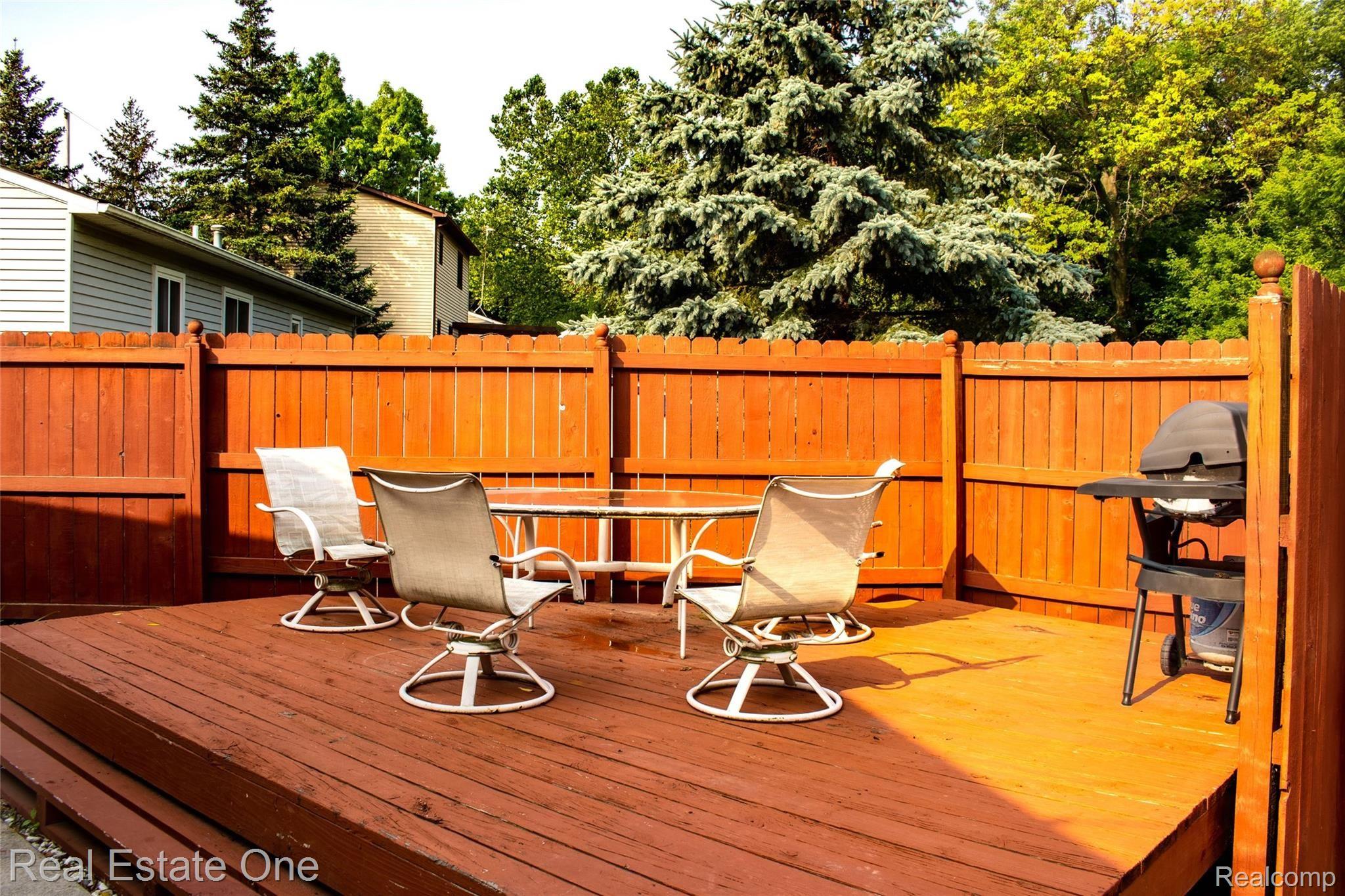 517 West High Street Fenton, MI 48430 - Photo 31 of 33 Fenced deck are and blanket of tree behind. Remove 2 panels and have private wood view.