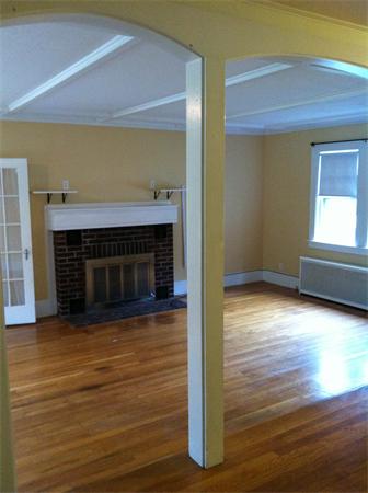 34 Wilkins Road Braintree, MA 02184 - Photo 4 of 12 a view of an empty room with wooden floor fireplace and a window