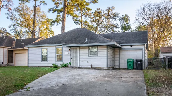a front view of house with yard and trees in the background