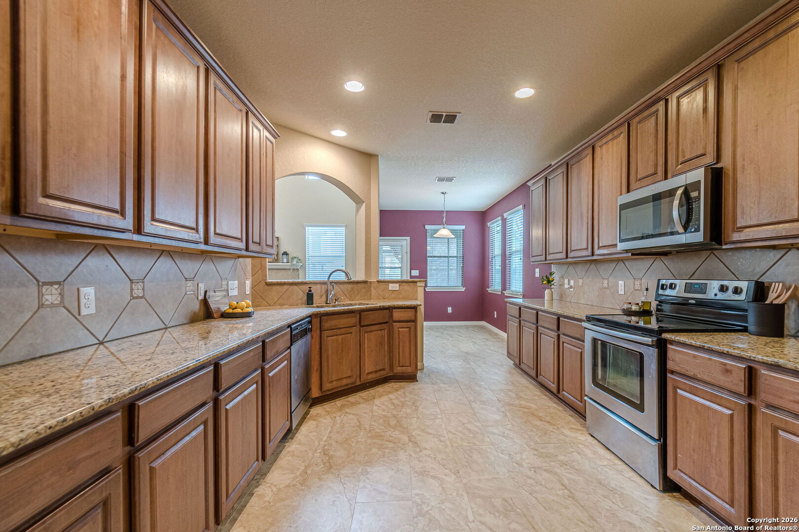 204 Wildcat Run Cibolo, TX 78108 - Photo 13 of 41 a kitchen with stainless steel appliances granite countertop wooden cabinets a stove top oven a sink and dishwasher