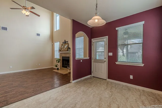 a view of an empty room with window and wooden floor