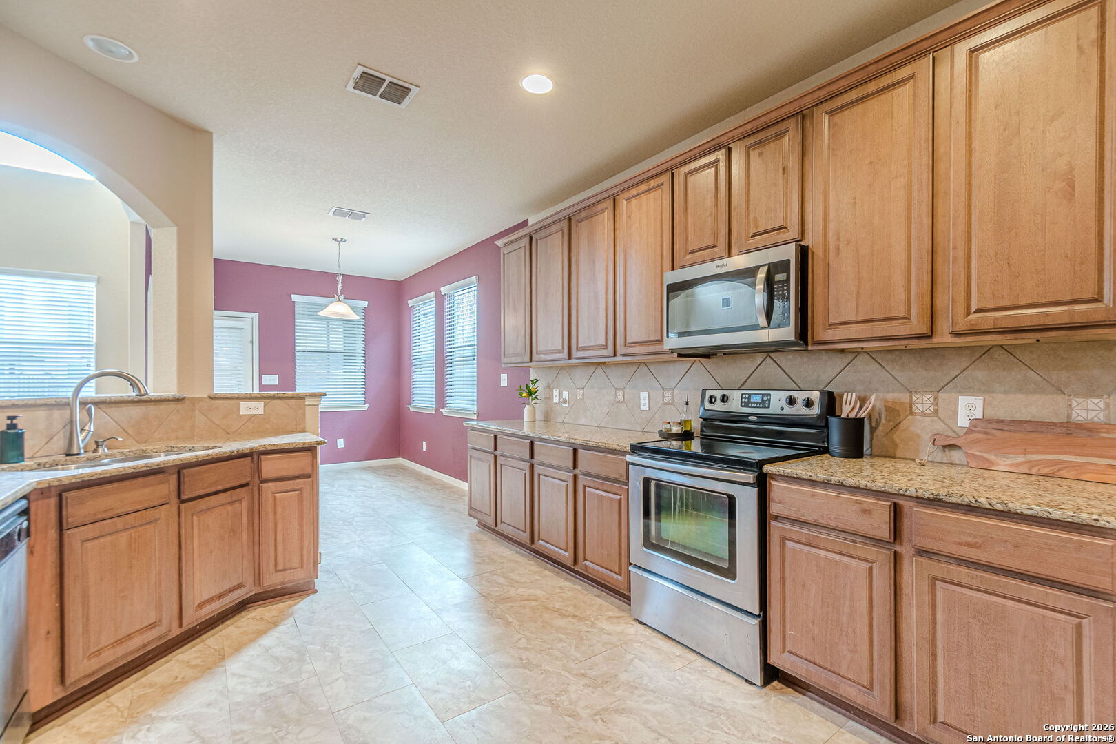 204 Wildcat Run Cibolo, TX 78108 - Photo 10 of 41 a kitchen with stainless steel appliances granite countertop a stove sink microwave and cabinets