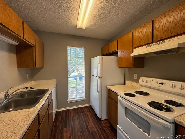 a kitchen with a stove a sink and a refrigerator
