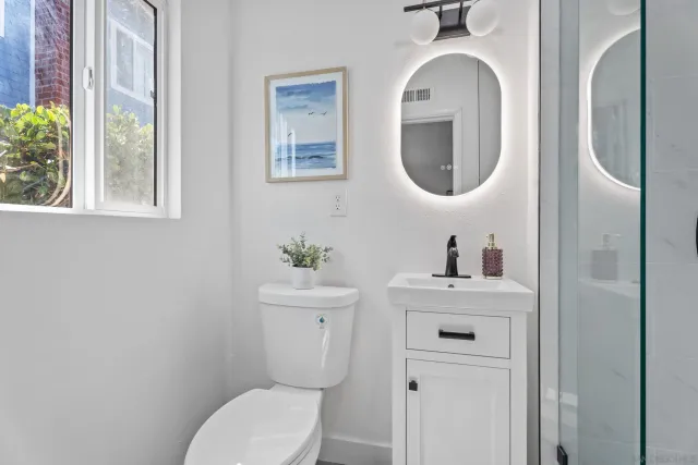a bathroom with a toilet sink and mirror