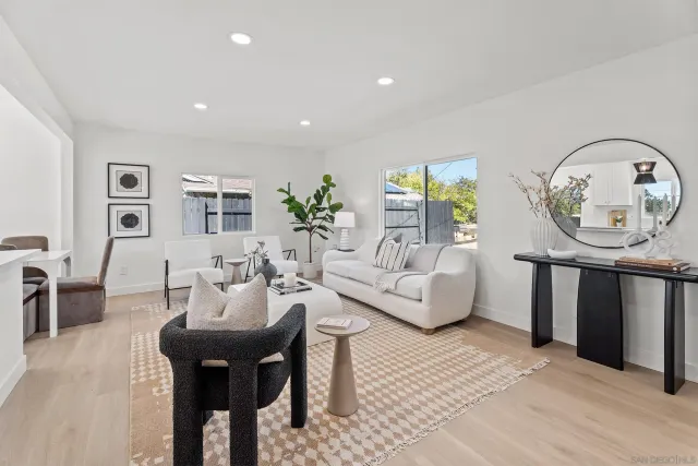 a living room with furniture a window and a potted plant