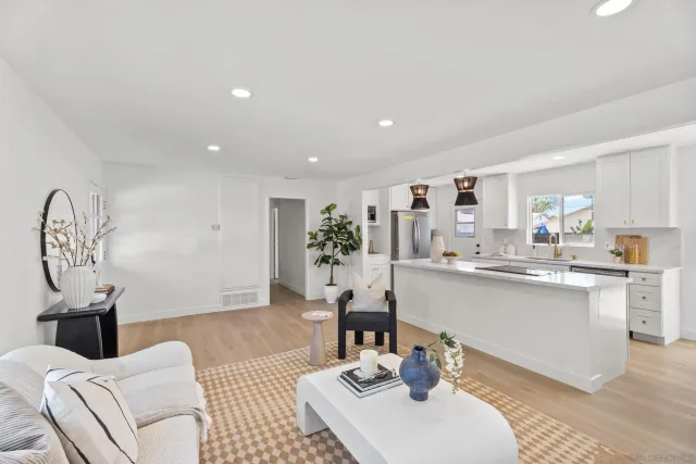 a living room with kitchen island furniture a sink and a large mirror
