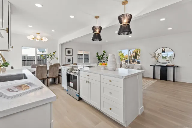 a kitchen with kitchen island white cabinets and stainless steel appliances