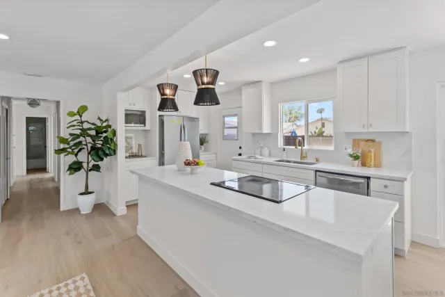 a kitchen with stainless steel appliances a sink a window and white cabinets