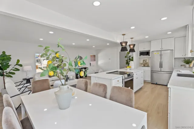 a kitchen with stainless steel appliances kitchen island granite countertop a sink a stove a dining table and chairs