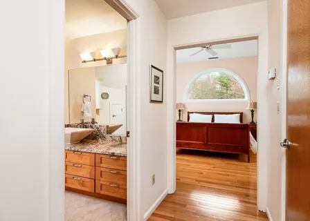 a en suite bathroom with a granite countertop sink and a mirror