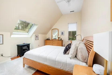 a bedroom with a bed and a lamp with the dresser