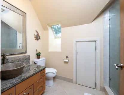 a spacious bathroom with a granite countertop sink a toilet and a mirror