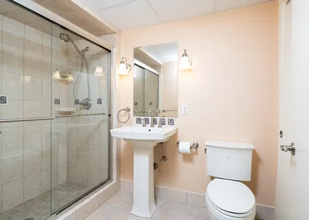 a bathroom with a sink a toilet and shower