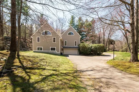 a large tree in front of a house with a yard