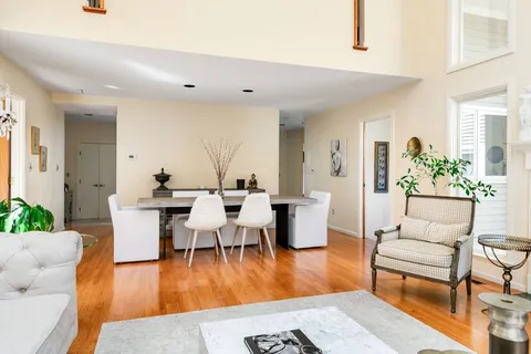 a living room with furniture wooden floor and a table