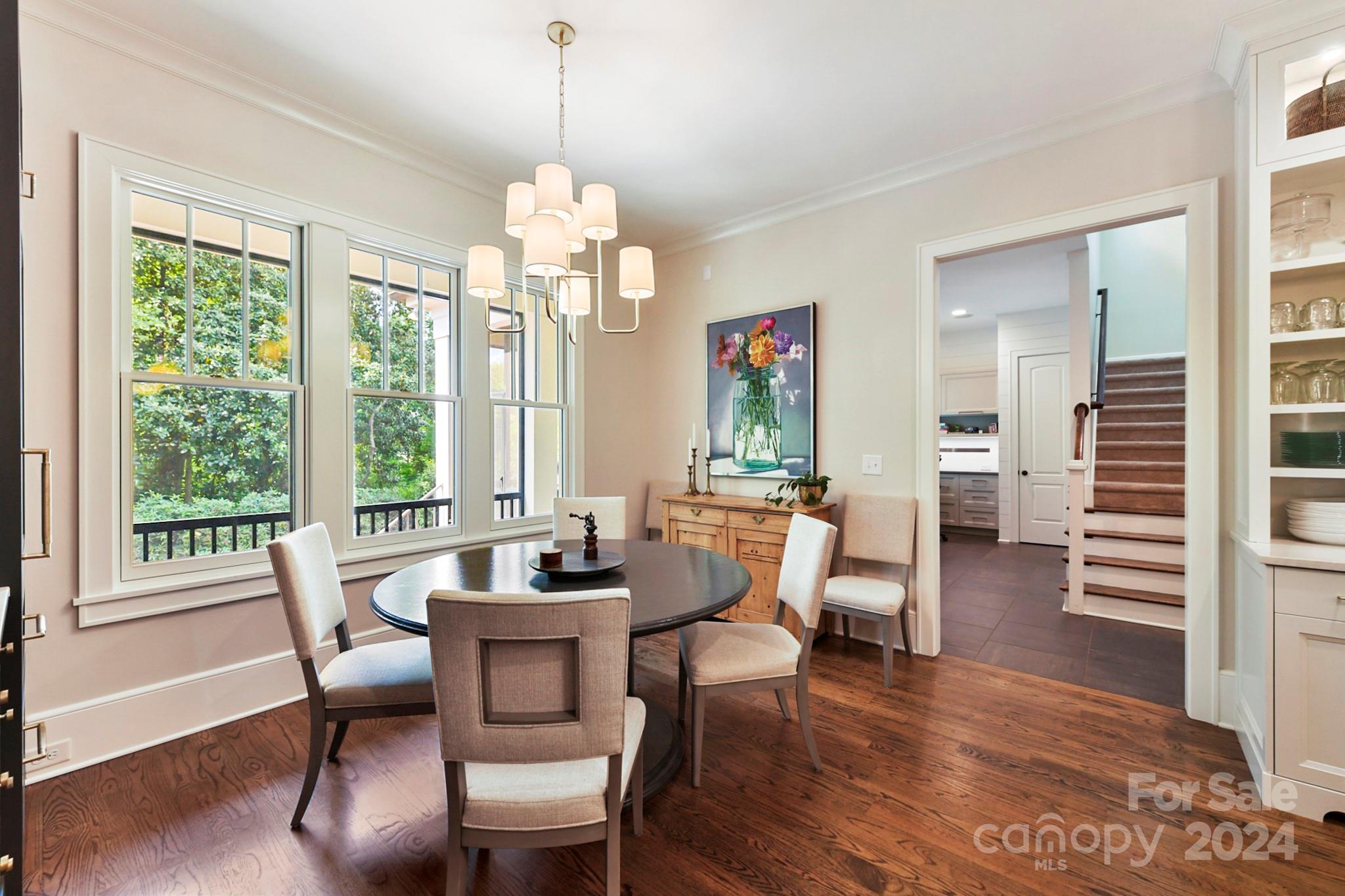 3201 Wickersham Road Charlotte, NC 28211 - Photo 11 of 43 a dining room with wooden floor a chandelier a wooden table and chairs