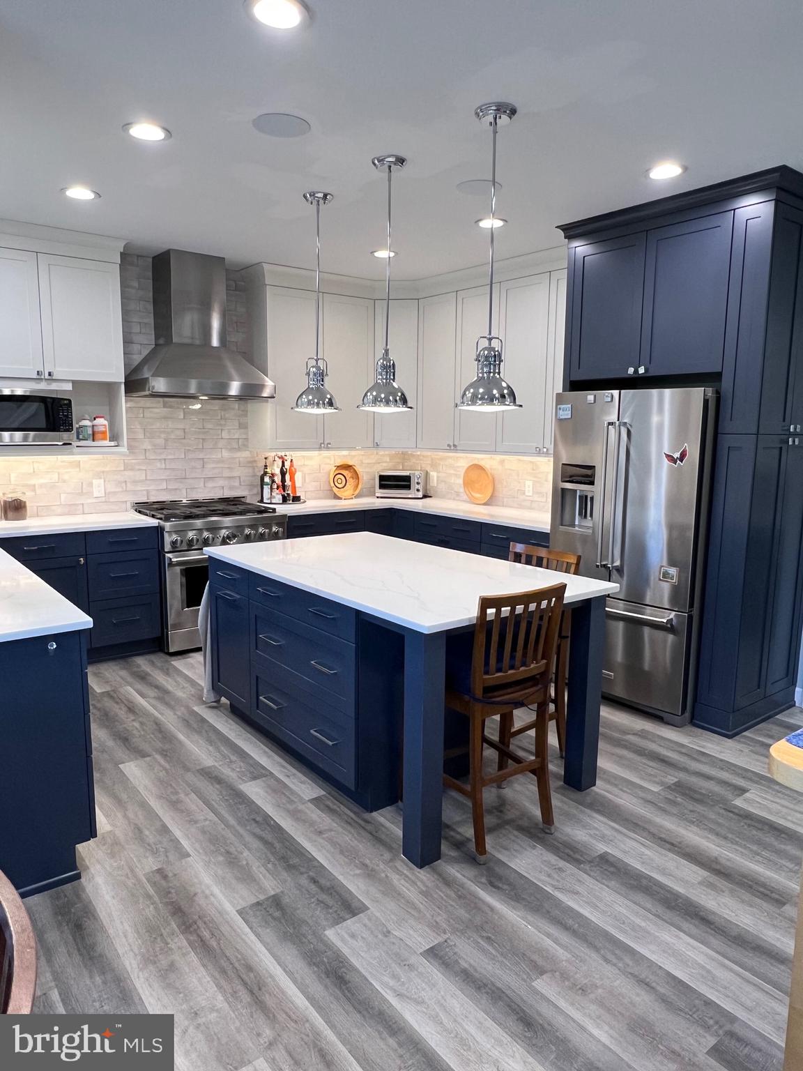 9706 Hidden Valley Road Vienna, VA 22181 - Photo 13 of 43 a kitchen with stainless steel appliances granite countertop a table chairs sink refrigerator and cabinets