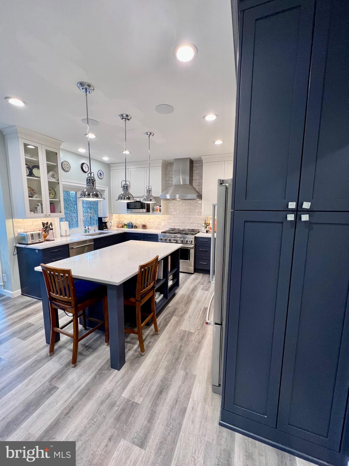 9706 Hidden Valley Road Vienna, VA 22181 - Photo 20 of 43 a kitchen with kitchen island a wooden floor and white cabinets
