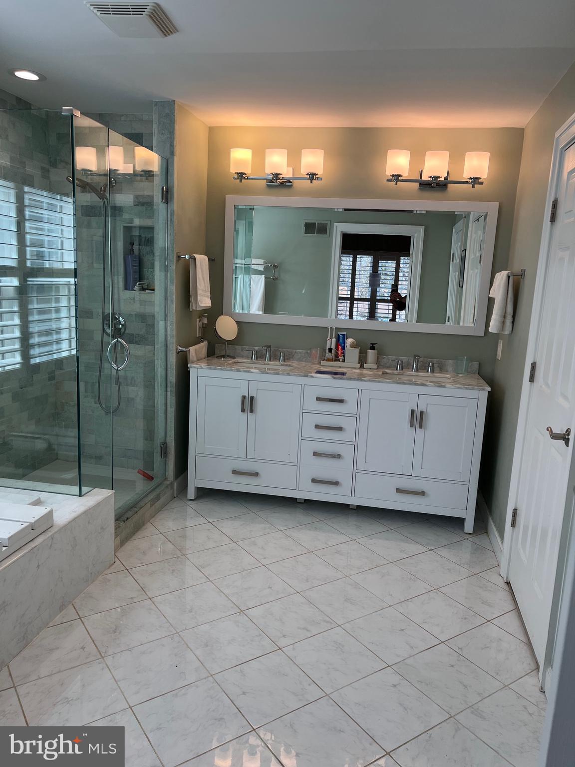 9706 Hidden Valley Road Vienna, VA 22181 - Photo 28 of 43 a bathroom with a sink a mirror and a bathtub