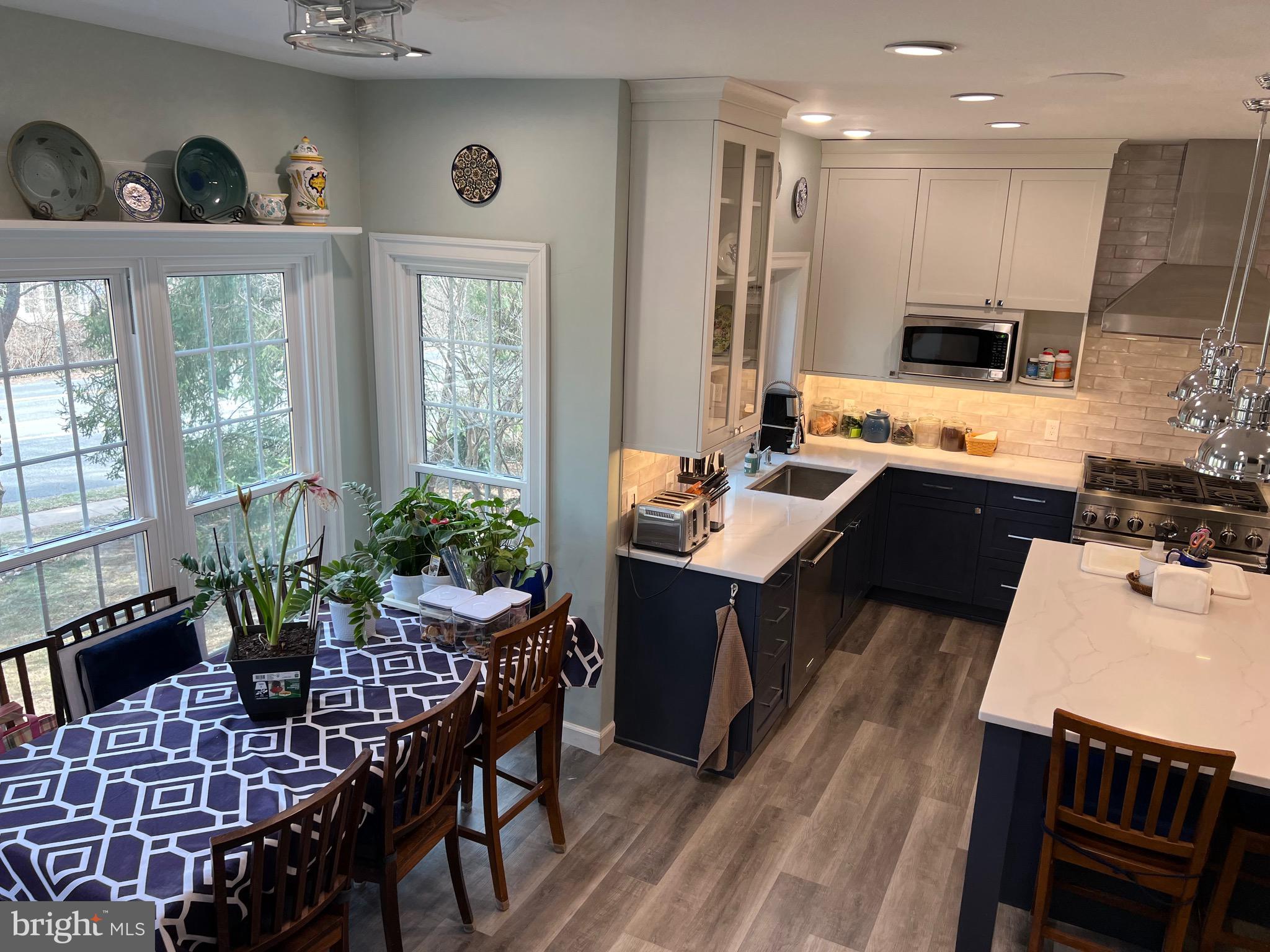 9706 Hidden Valley Road Vienna, VA 22181 - Photo 33 of 43 a kitchen with a table chairs stove and cabinets