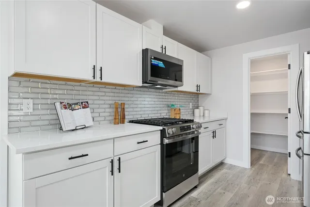 a kitchen with stainless steel appliances granite countertop a stove and a microwave