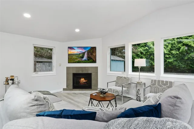 a living room with furniture fireplace and a large window