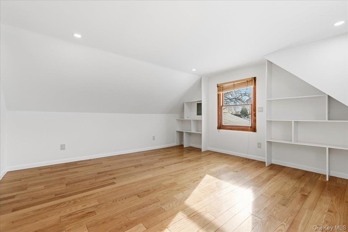 85 Briarcliff Road Westbury, NY 11590 - Photo 24 of 31 Bonus room with light wood-style floors, vaulted ceiling, recessed lighting, and built in shelves