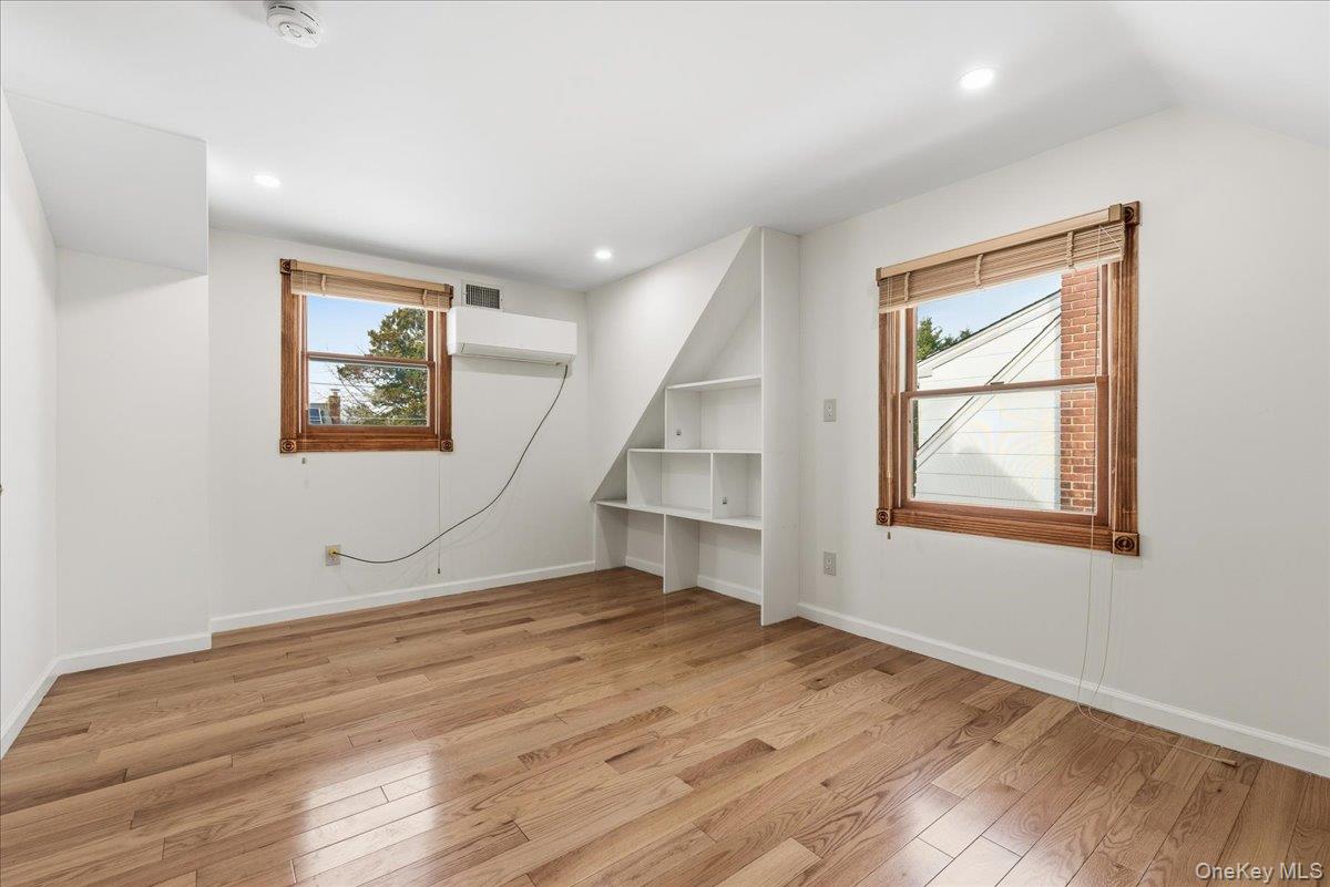 85 Briarcliff Road Westbury, NY 11590 - Photo 26 of 31 Empty room with light wood-style floors, recessed lighting, and a wall unit AC
