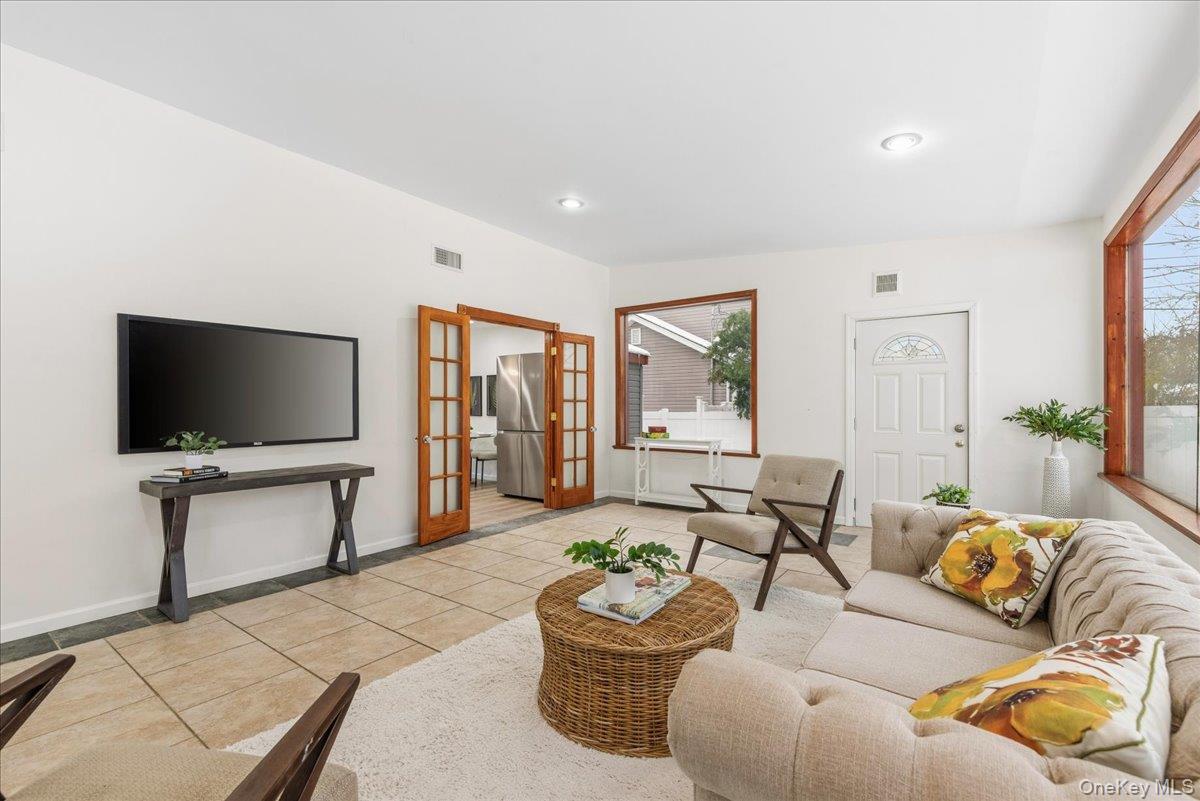 85 Briarcliff Road Westbury, NY 11590 - Photo 4 of 31 Living room featuring french doors, light tile patterned floors, recessed lighting, and plenty of natural light